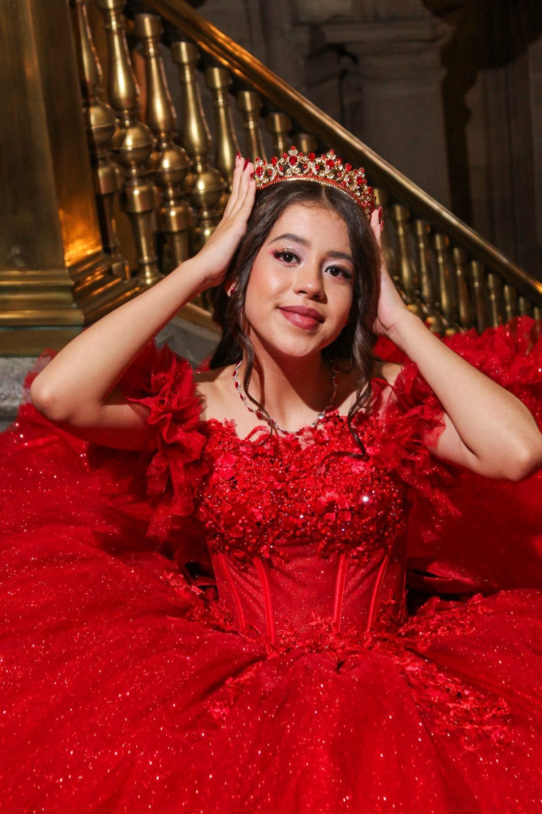 Quinceañera con corona y vestido rojo